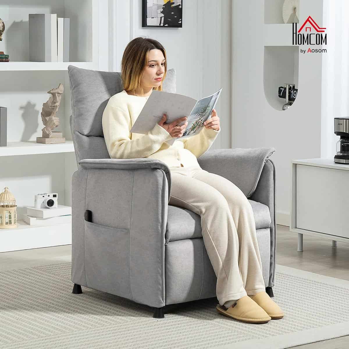 Frau sitzt in einem grauen Sessel und liest eine Zeitschrift in einem modernen Wohnzimmer.